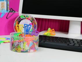 Das Bild zeigt fröhlich-bunte Plastiklips im Büro